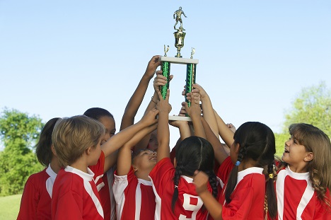 Children Upholding Soccer Trophy