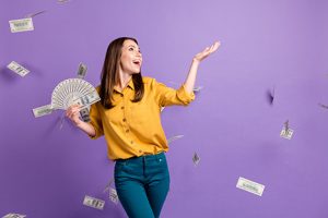 Image of a woman rollicking in cash