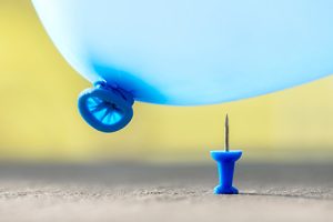 Image of a thumbtack near a balloon