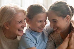 Image of a grandma, a mother and a daughter hugging