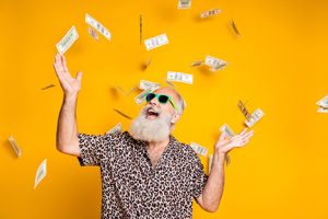 Image of a bearded man playing in raining cash