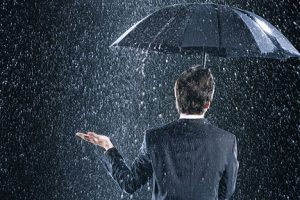 Image of an investor staying dry under an umbrella