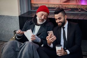 Image of a homeless man and a suited man