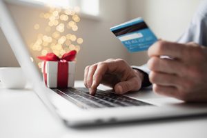 Person using a credit card to shop online during the holidays