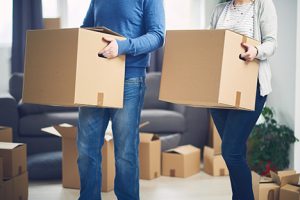 Couple carrying moving boxes