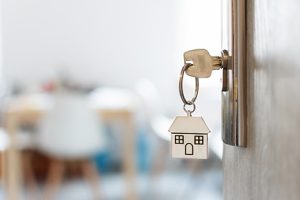 Key with keychain in a house shape in the door keyhole