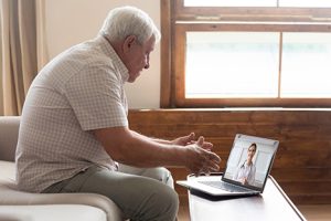 Elderly man doing a telehealth visit with doctor