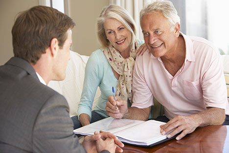 Image of an elderly couple meeting with an advisor