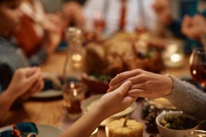 Family giving thanks before their Thanksgiving dinner 