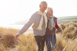 A couple smiling as they walk on the beach