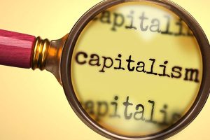 The word “capitalism” under a magnifying glass