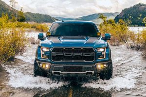 A Ford truck driving through shallow water