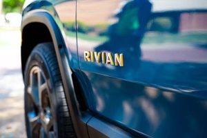 The logo for Rivian Automotive on the side of a car