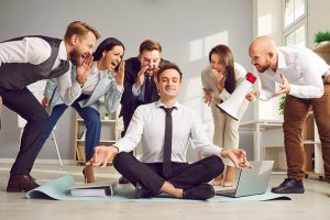 A calm businessman surrounded by 5 people screaming at him