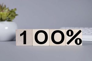 “100%” written onto four wooden blocks