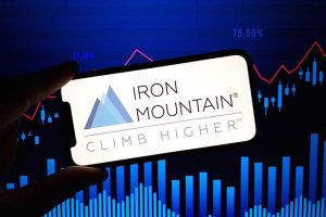 A smartphone showing the logo of Iron Mountain and the phrase “Climb Higher”