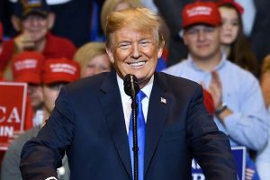 President Donald Trump smiling while standing behind a podium