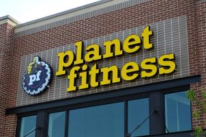 The Planet Fitness logo in front of one of the company’s buildings