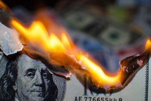 A close-up of a $100 bill on fire
