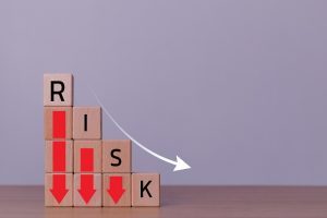 Progressively smaller stacks of blocks with the word “risk” and downward-facing arrows on them