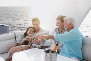 A retirement-age couple and a younger couple drinking champagne on a boat
