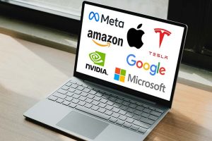 A laptop showing the logos of the “Magnificent Seven” stocks