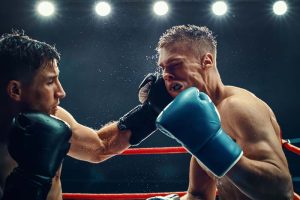 Two boxers in the ring, with one punching the other in the face