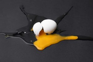 A broken egg on a black surface