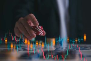 A hand holding a stack of poker chips, with a stock chart in the foreground