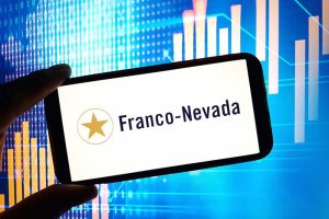 The Franco-Nevada logo on a smartphone in front of a rising stock chart