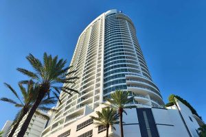 A tall hotel with palm trees in front of it