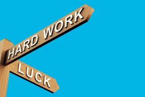 Two street signs labeled “hard work” and “success” pointing in different directions