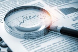 A magnifying glass on top of a financial chart