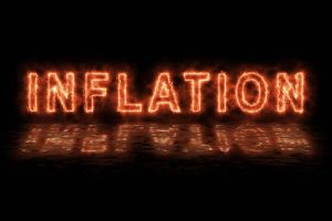 The word “INFLATION” in flaming, orange text