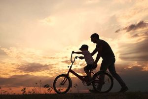 A father helping his son ride a bike