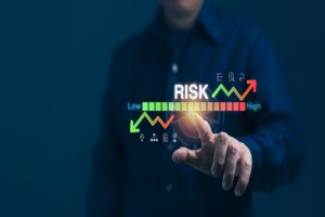 An investor lifting their hand to a red-to-green “risk” meter