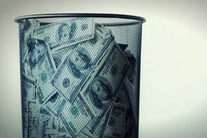 A trash can full of U.S. dollar bills