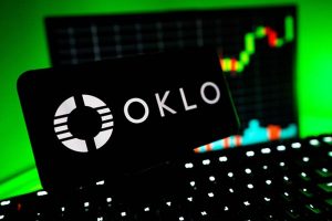 The Oklo logo on a smartphone with a stock chart in the background
