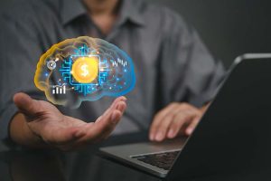 An investor sitting at a desk in front of a laptop with a technological brain hovering over his outstretched hand