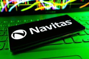 The Navitas Semiconductor logo on a smartphone lying on a laptop keyboard
