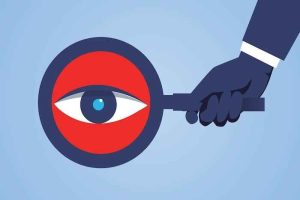 A cartoon hand holding a magnifying glass with an eye inside it