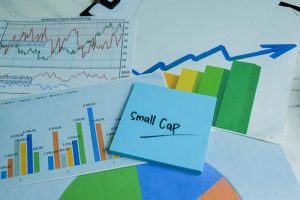 “Small cap” written on a blue sticky note next to several stock charts