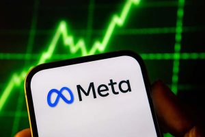 The Meta Platforms logo on a smartphone in front of a green, rising stock chart